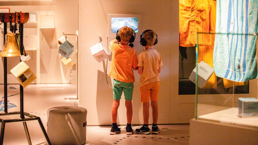 To barn som ser på skjerm i utstilling