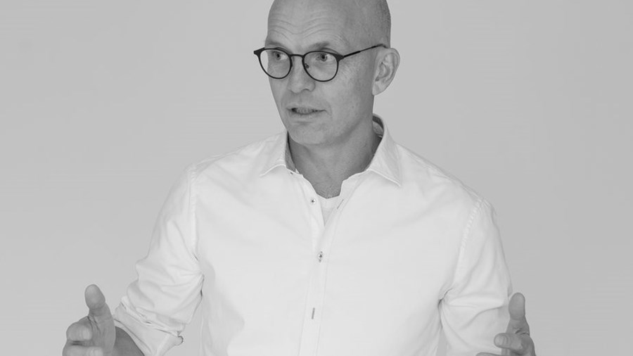 En mann med hvit skjorte og briller på.