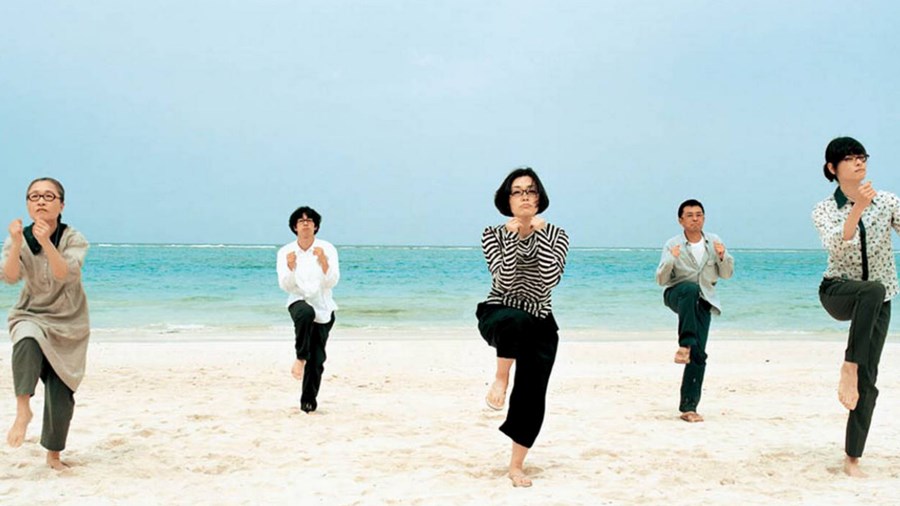 mennesker på stranden som gjør Tai Chi