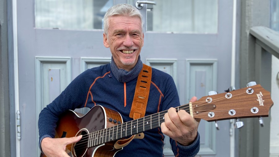 Smilende mann med gitar