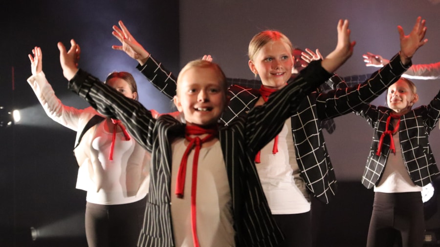 Barn som smiler og danser i kostymer